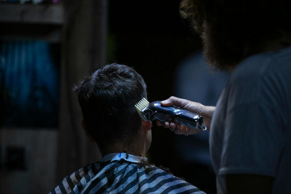 Man Using Hair Clippers on Another Man’s Hair