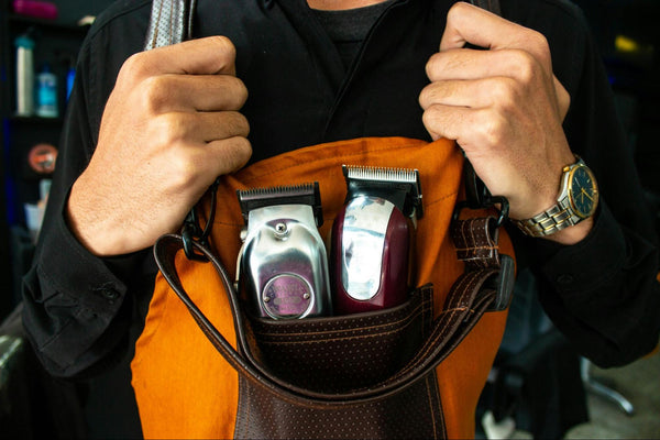 Person Wearing Orange Apron with Two Hair Clippers Inside