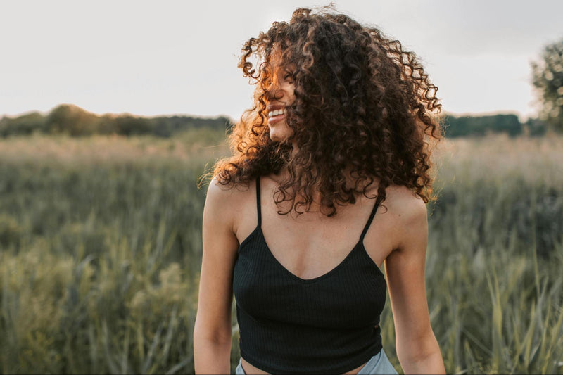 Woman with curly hair in a field