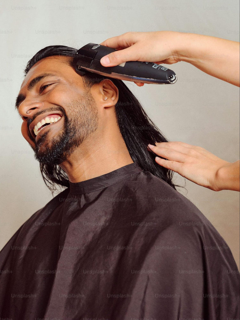 A man getting his hair done with a clipper.