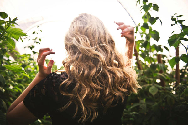 Woman with Blonde Curly Hair Between Green Plants