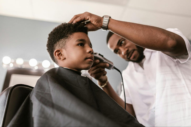 Man Using Hair Clippers on Little Boy’s Hair