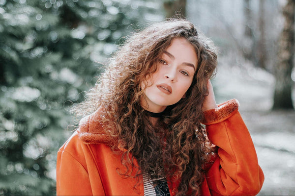 Woman in Orange Coat with Curly Hair