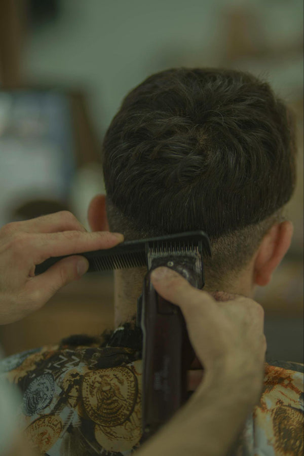 Man Cutting Another Man’s Hair with Hair Clippers