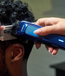 Andis navy brushless motor clipper trimming hair with a comb