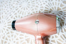 Rose gold hair dryer close-up on the barrel with black air outlet