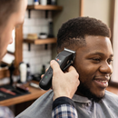 Black hair clipper in hand near a man’s beard, green indicator light visible
