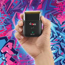Black electric shaver held in hand, gold foil head and green power indicator