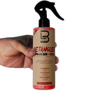 Hair detangling spray bottle with black trigger sprayer, held by a hand.