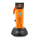 StyleCraft Saber 2 cordless clipper on charging base, orange body and black stand
