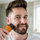 Orange cordless clipper held to a man’s beard for facial hair grooming