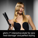 Black flat iron held upright with long plates for straightening hair