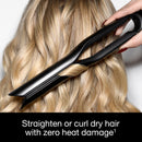 Black flat iron gliding through blonde hair with slim ceramic straightening plates