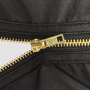 Black apron front close-up with gold zipper pull and stitching