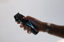 Black cordless hair clipper held in hand, blade head facing left