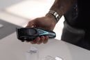 Wahl cordless clipper in hand, black body with blue light indicators