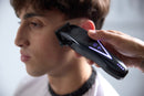 Wahl cordless hair clipper in hand with purple control lights during grooming