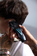 Wahl cordless hair clipper trimming hair, blue light accents on the handle