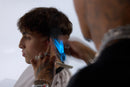 Wahl cordless hair clipper creating blue vapor while edging near the ear