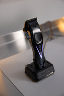 Wahl cordless hair clipper standing on dock, side profile with purple V-shaped light